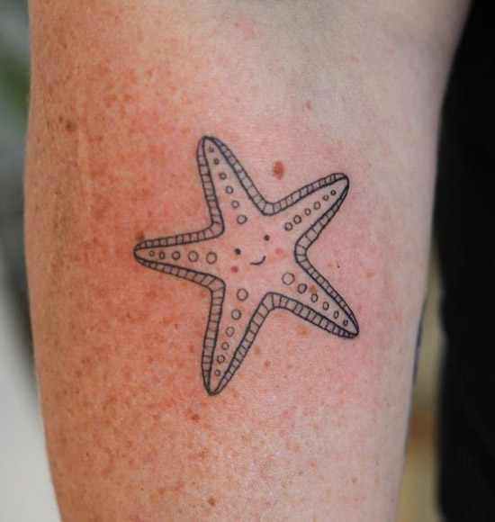 Little starfish tattoo located on the upper arm